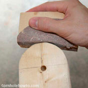 Sanding the rounded ends of the table legs.